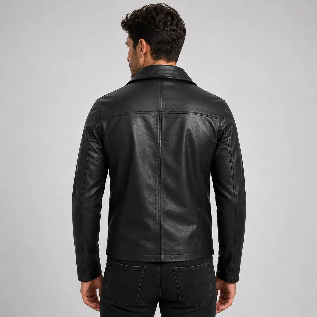 Man wearing a black leather jacket on a gray background